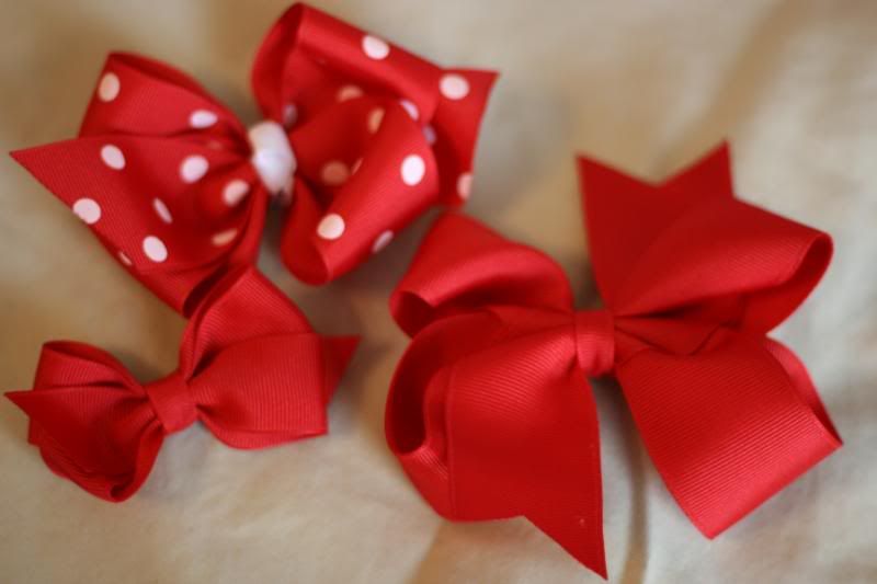 1 med. red with white dots bows, 1 small red boutique bow, and 1 medium red twisted boutique bow